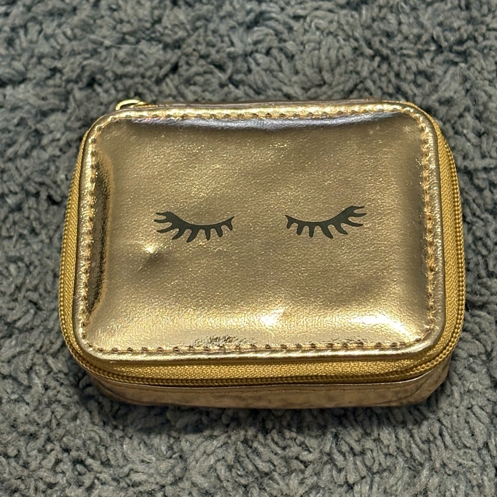 NWOT gold square pouch with eyelashes design